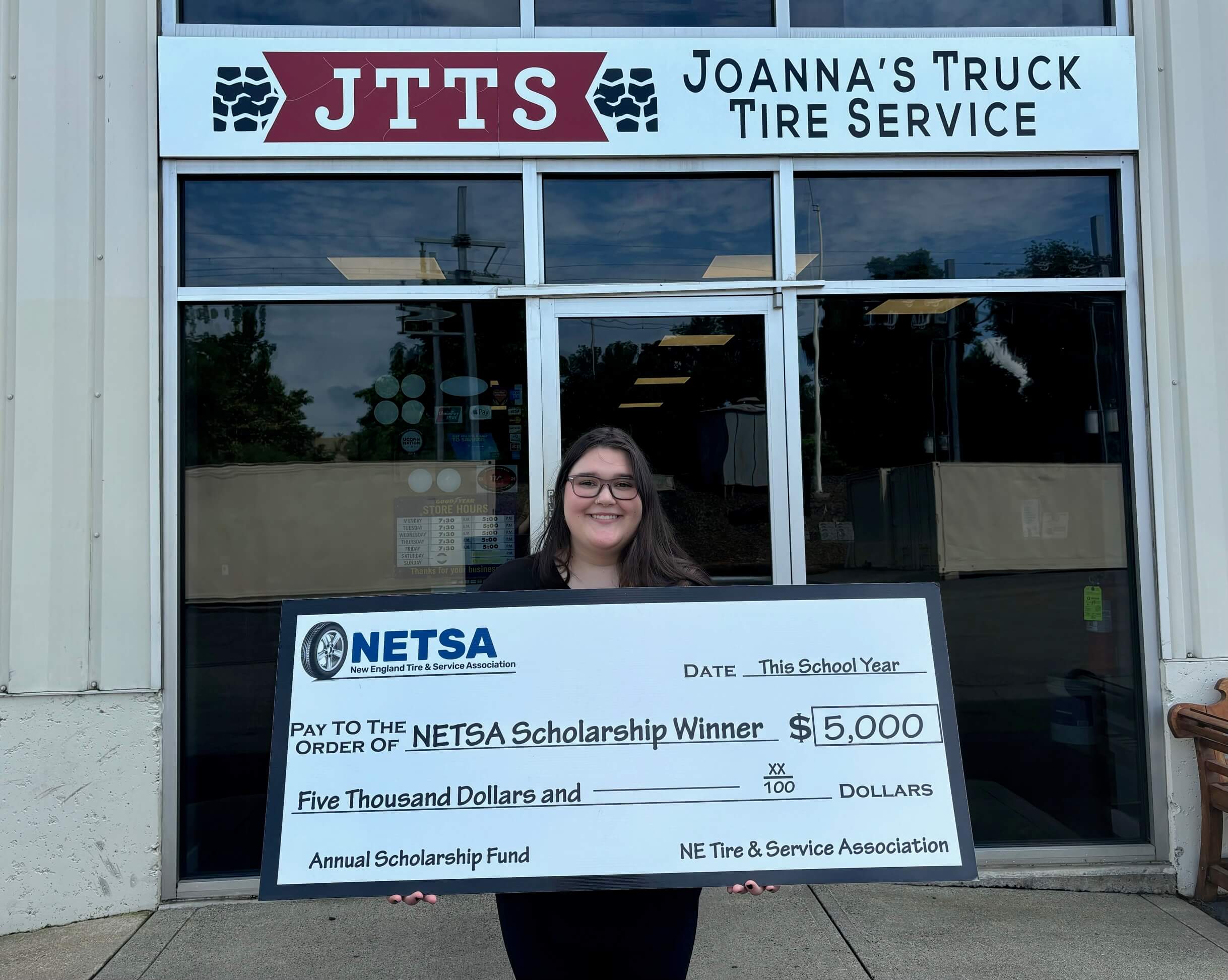 Megan holding big check for winning $5,000 NETSA scholarship